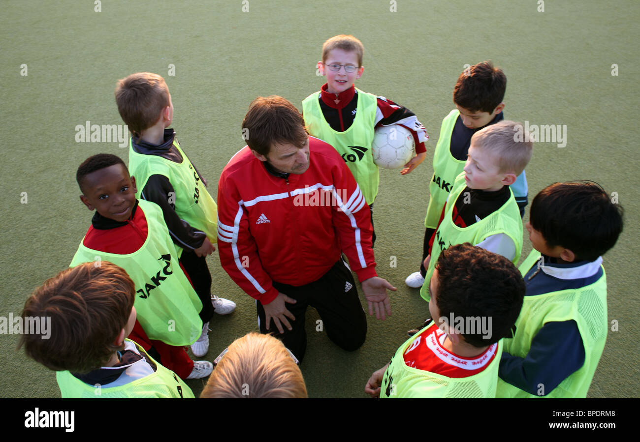 A coach talking to children during soccer practice, Berlin, Germany Stock Photo