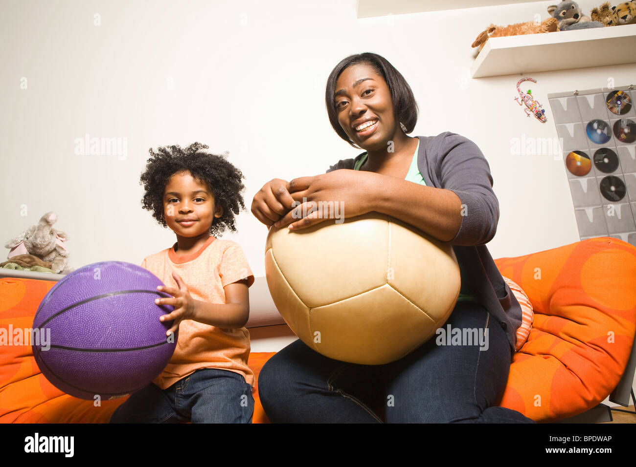 African American mother and son holding balls Stock Photo