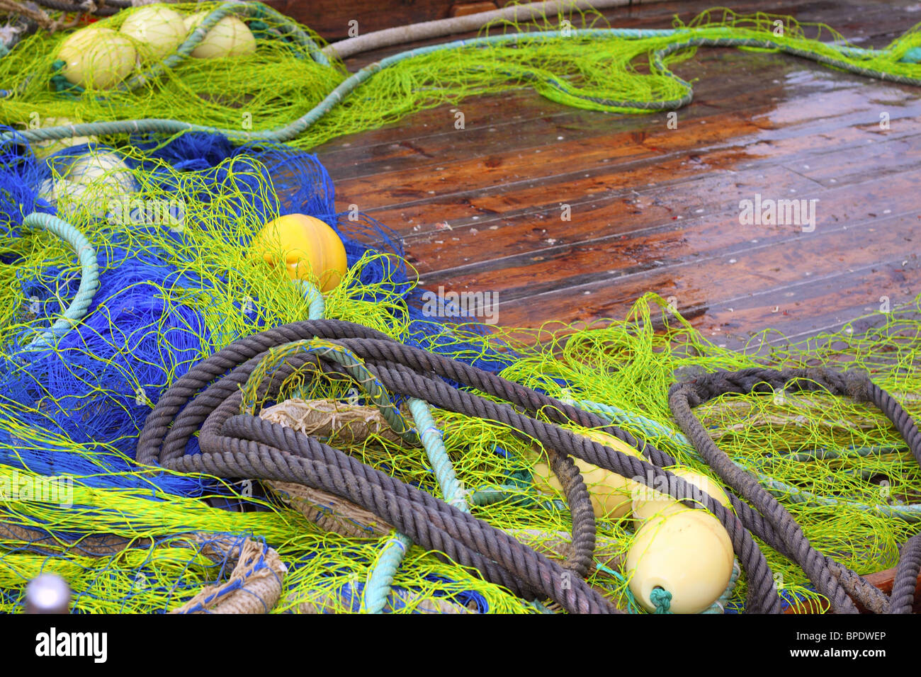 fishermen professional tackle net on boat wooden wet deck Stock Photo