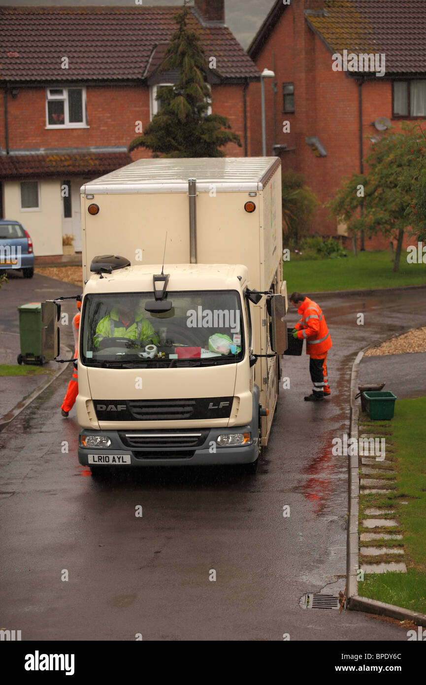 August 2010 - Refuse recycling truck and crew in action on a wet day in the rain Stock Photo