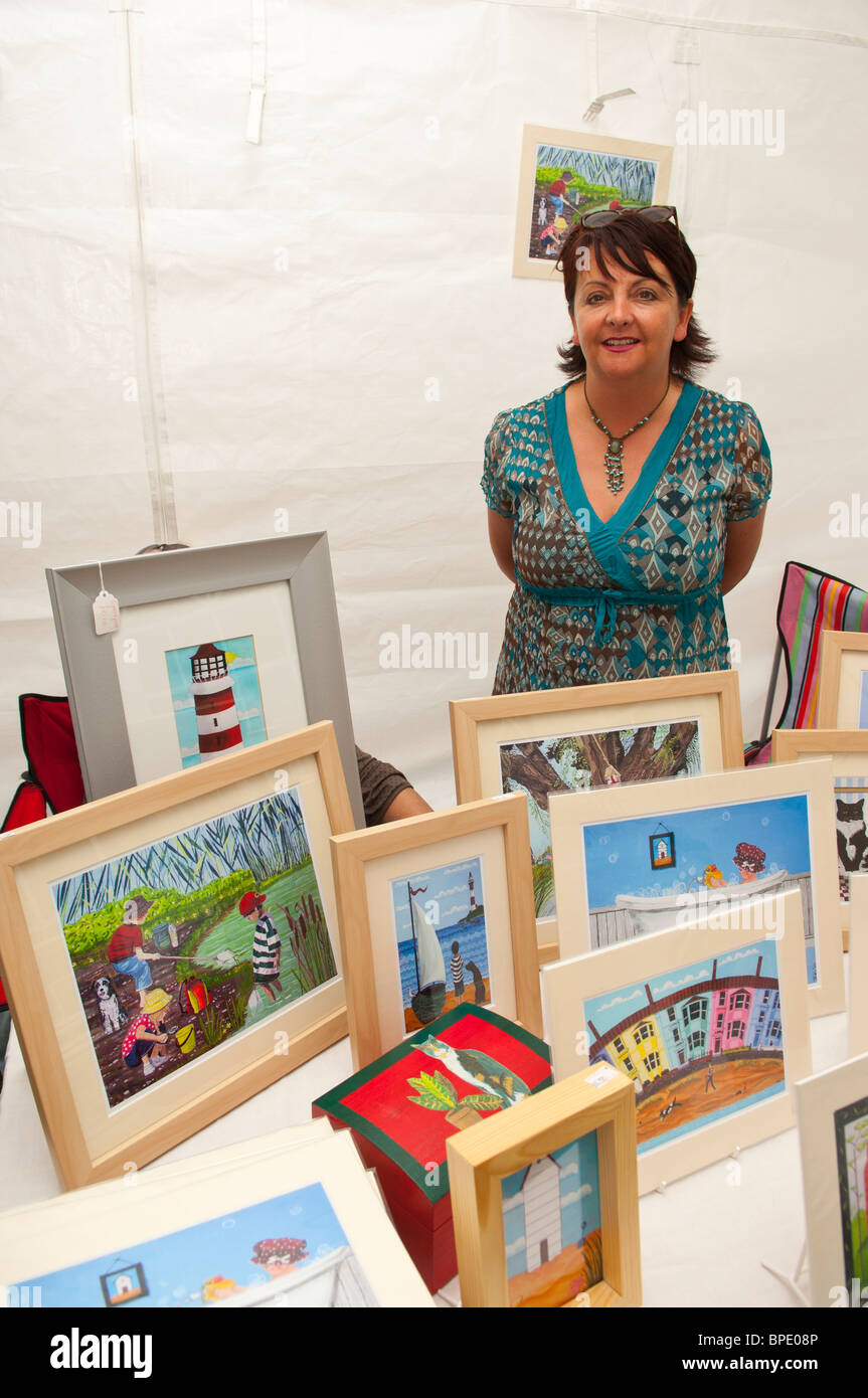 Tracey Kemp the talented Suffolk Artist with a range of her unique pictures on a stall at a Uk fete Stock Photo