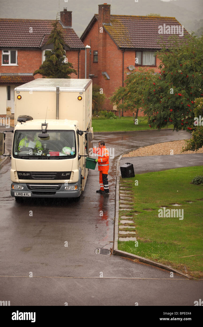 August 2010 - Refuse recycling truck and crew in action on a wet day in the rain Stock Photo
