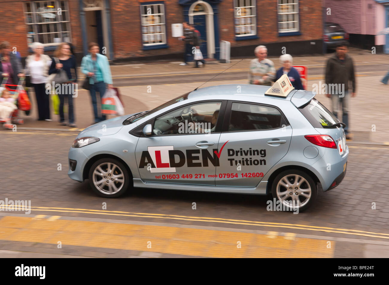 A Learner driver on a lesson drives through the city showing movement in Norwich , Norfolk , England , Great Britain , Uk Stock Photo