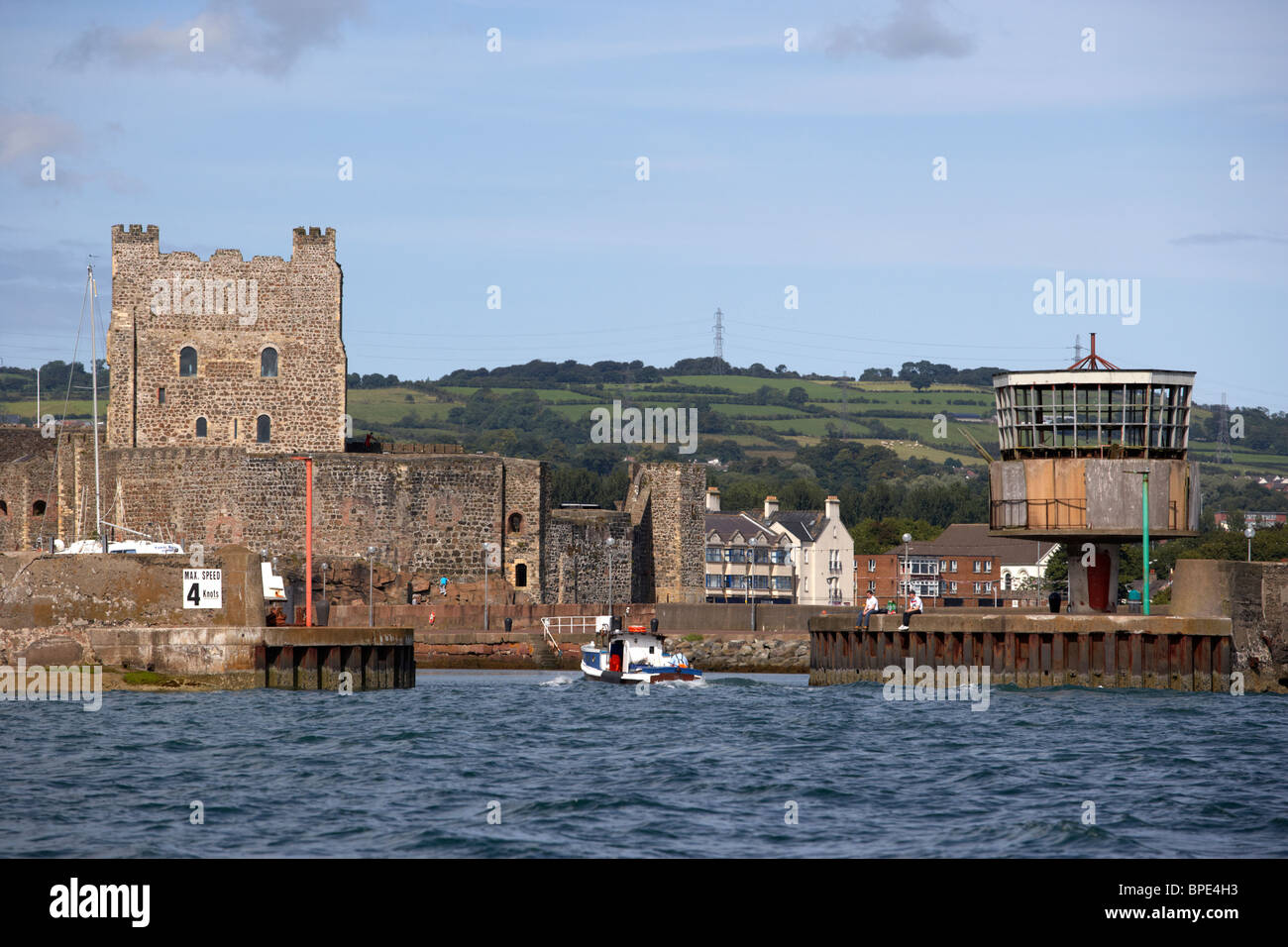 boat entering carrick harbour approaching carrickfergus castle county antrim northern ireland uk viewed from the sea Stock Photo