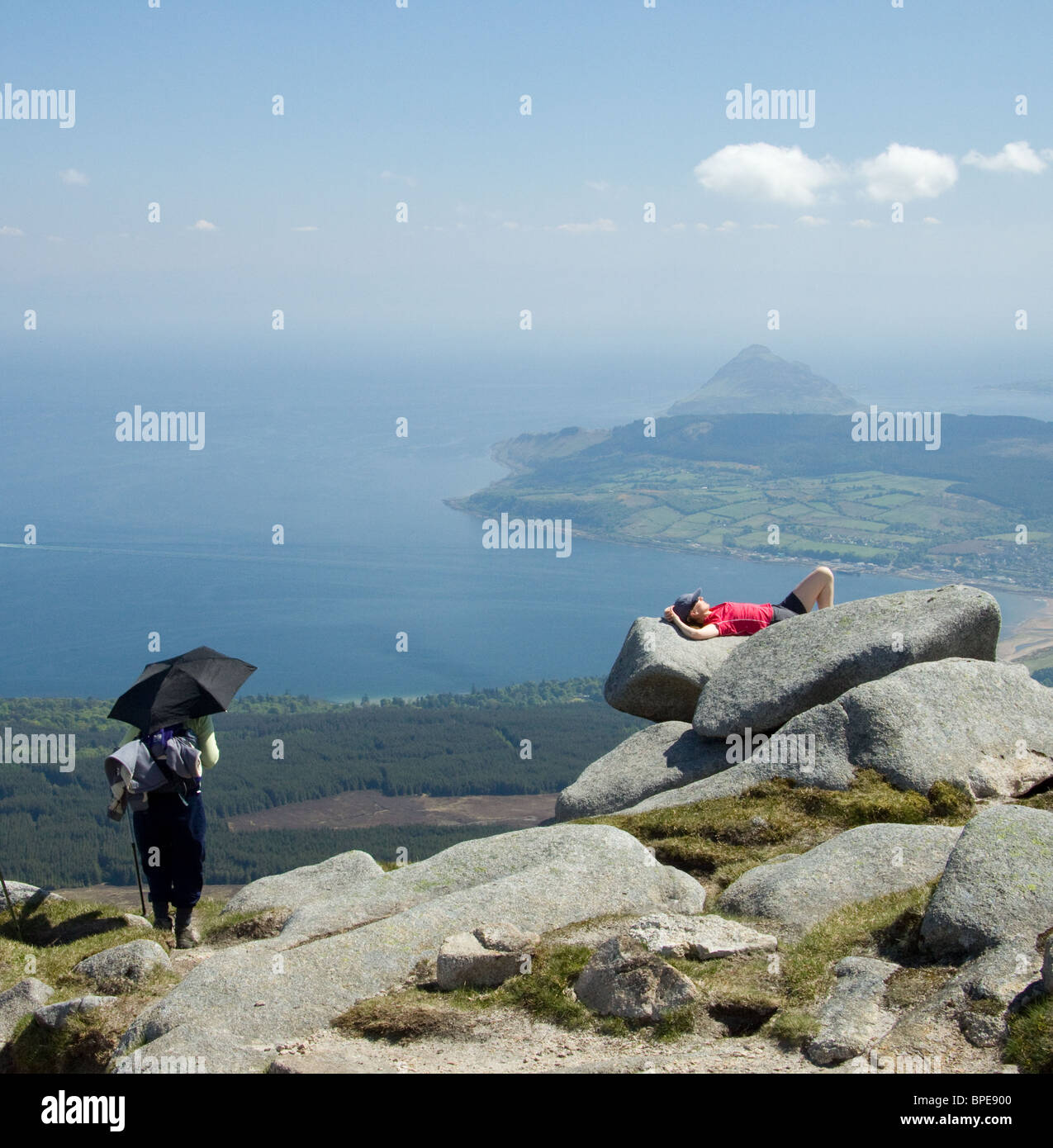 Different ways of dealing with the sun on the summit of Goat Fell, the highest mountain on the Isle of Arran, Scotland. Stock Photo
