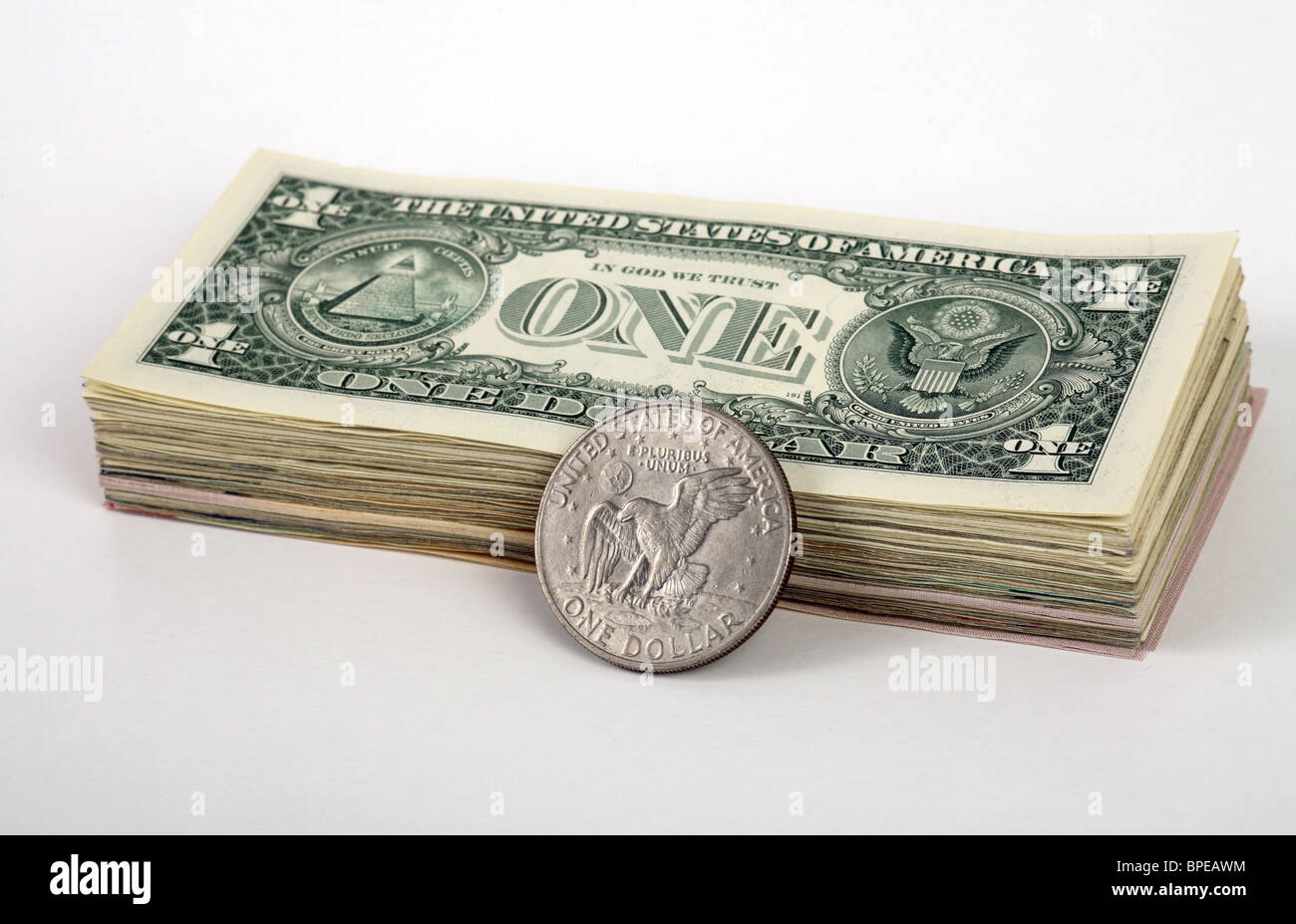 A wad of 1-dollar banknotes and a dollar coin Stock Photo