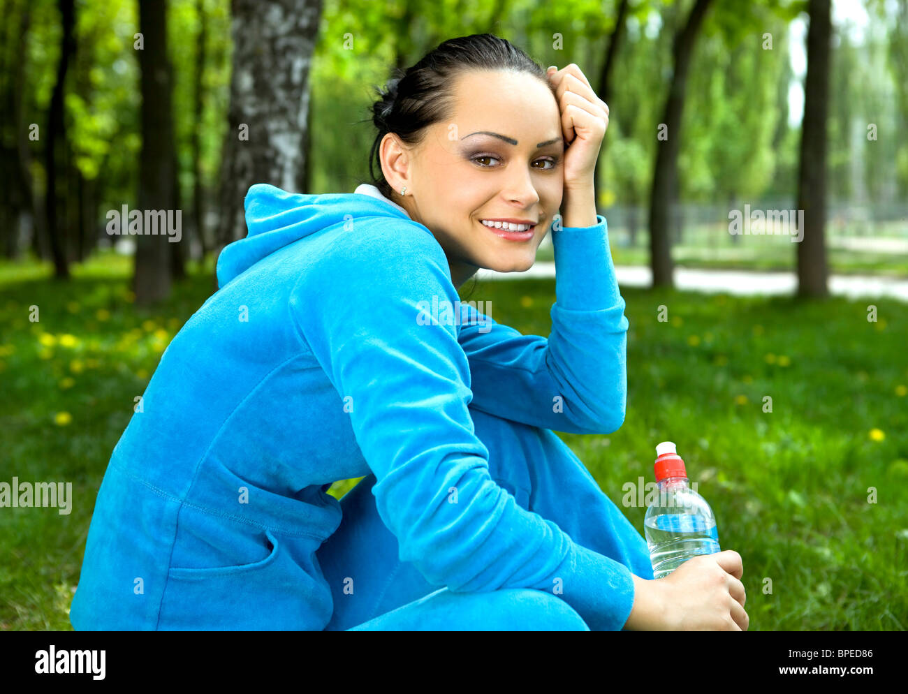 Pretty young girl runner in the forest with bottle of water Stock Photo