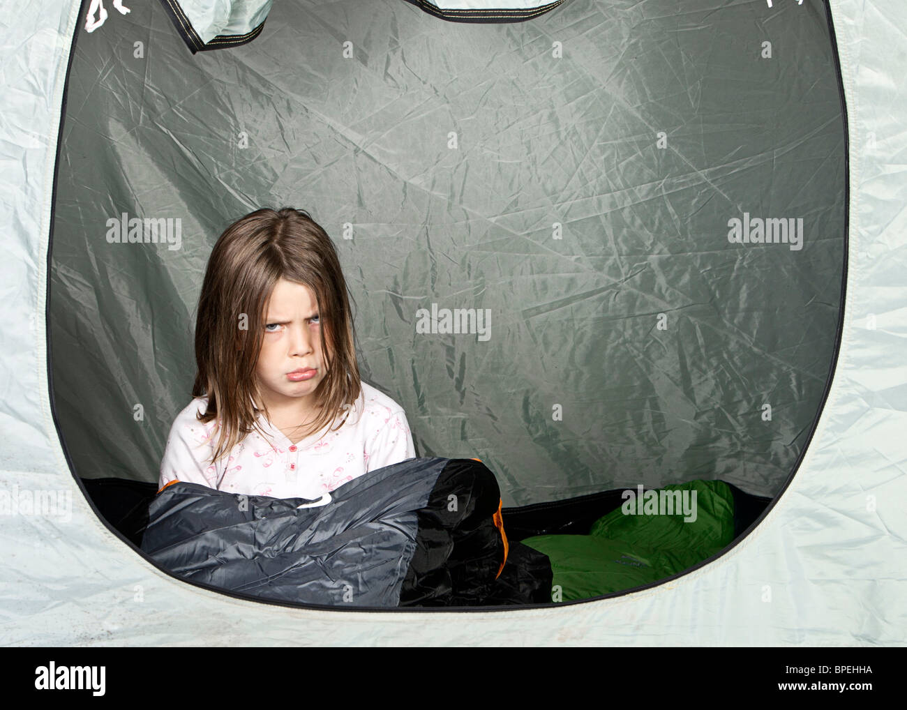 Shot of a Young Girl Looking Unhappy about Camping Stock Photo