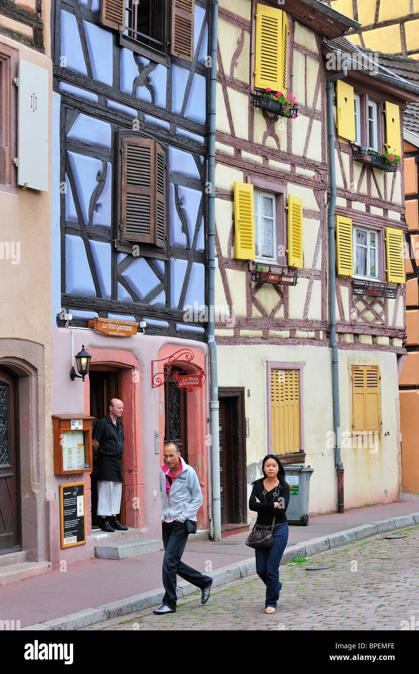 Tourists walking along colorful façades of timber framed houses at Petite Venise / Little Venice, Colmar, Alsace, France Stock Photo