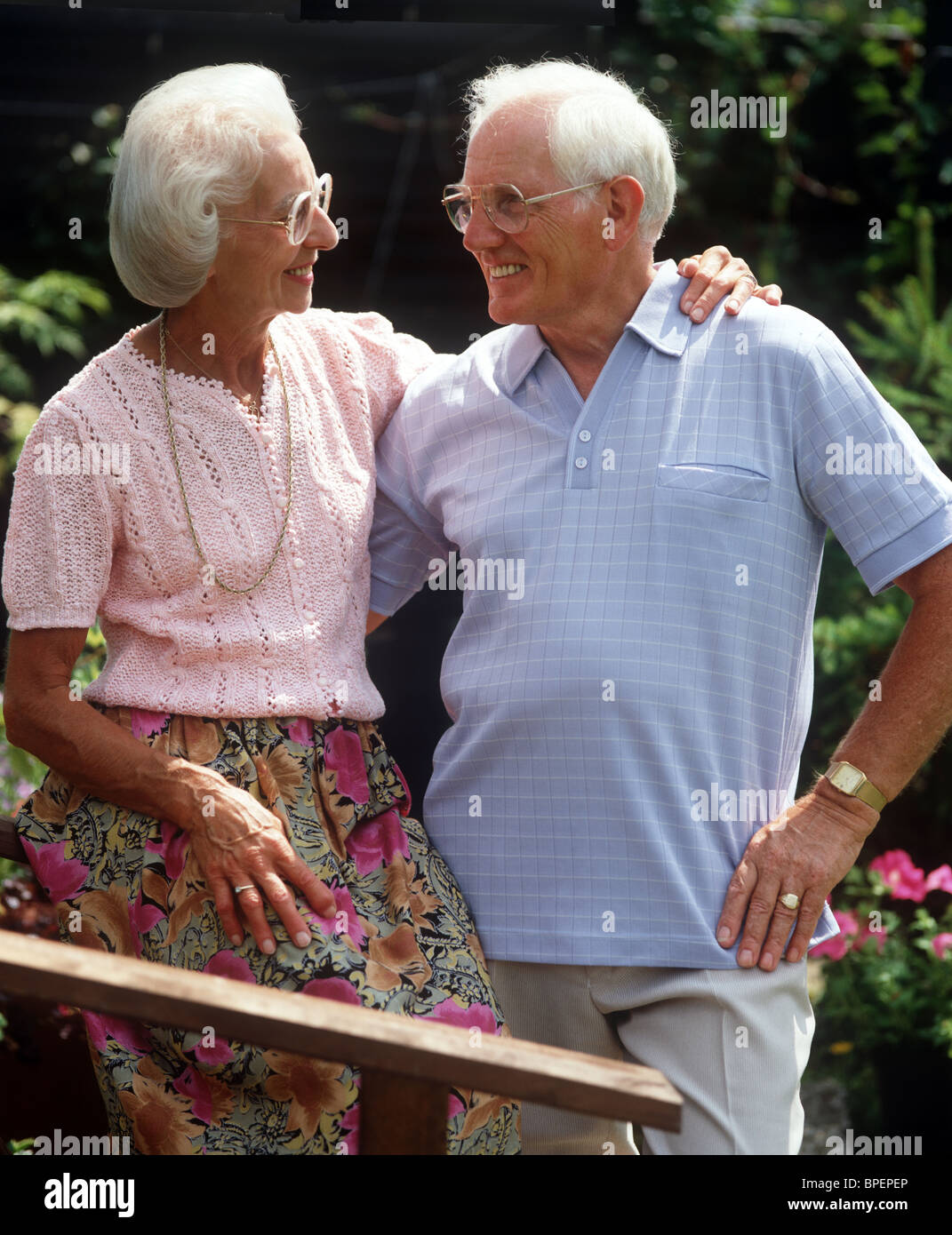 Old couple outdoors laughing in an embrace Stock Photo