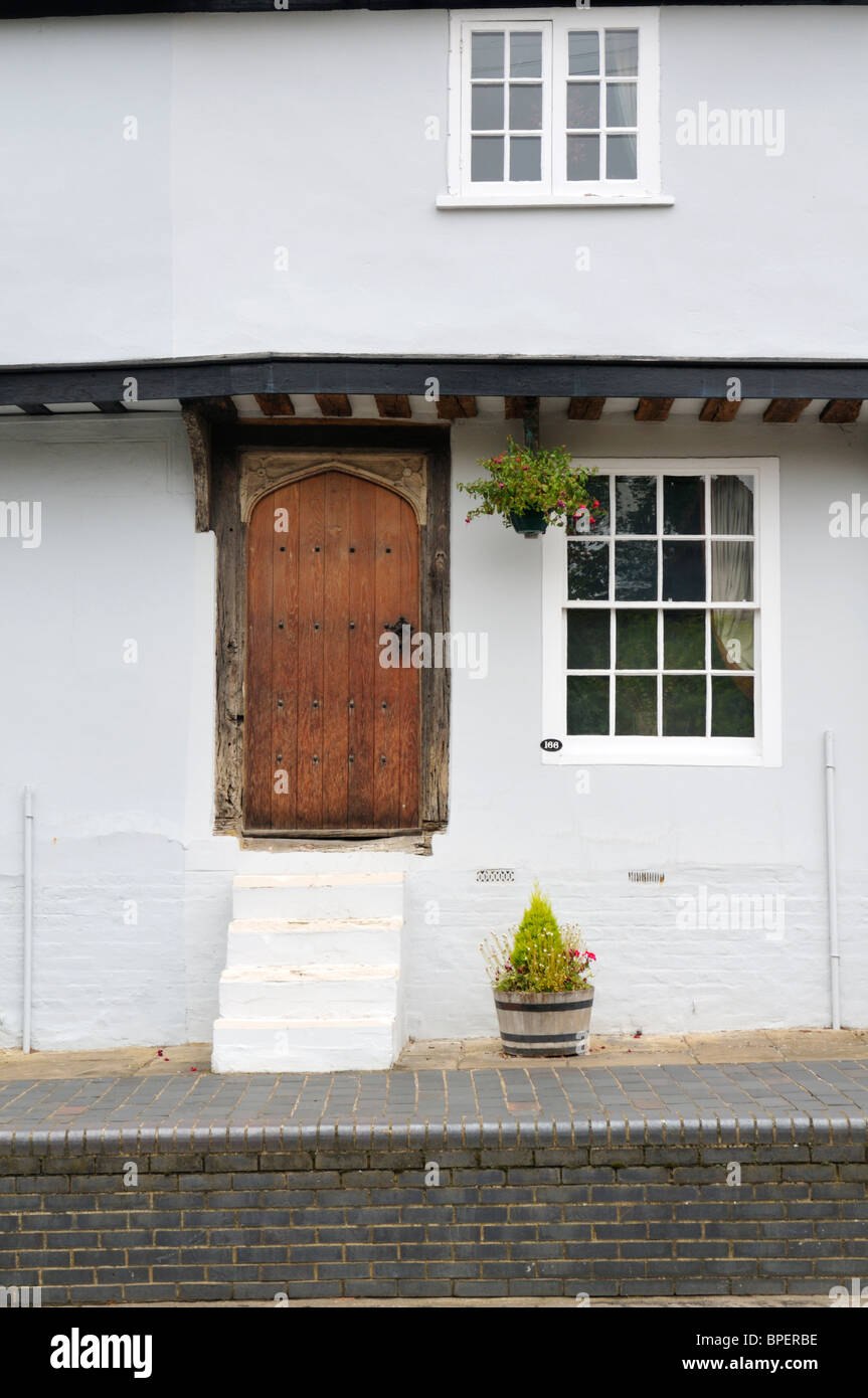 An old wooden front door reached by five steps from a raised pavement