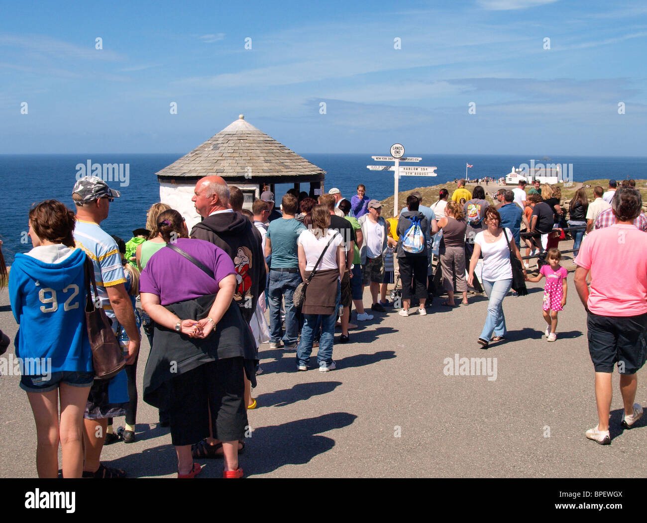 Queue of people to get photo taken in front of sign post at Land's End, Cornwall, UK Stock Photo