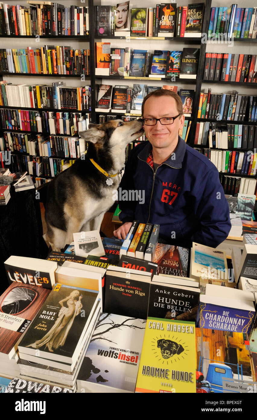 Dog's Kiss, 'Hammett', specialized bookstore for crime thrillers, owner Christian Koch and dog Polly, Kreuzberg, Berlin, Germany Stock Photo