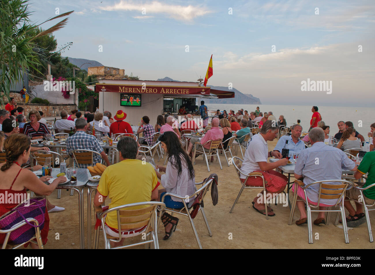 football fans watch the FIFA World Cup 2010 Final on large TV screens outside beach bar near Altea on the Costa Blanca, Spain Stock Photo