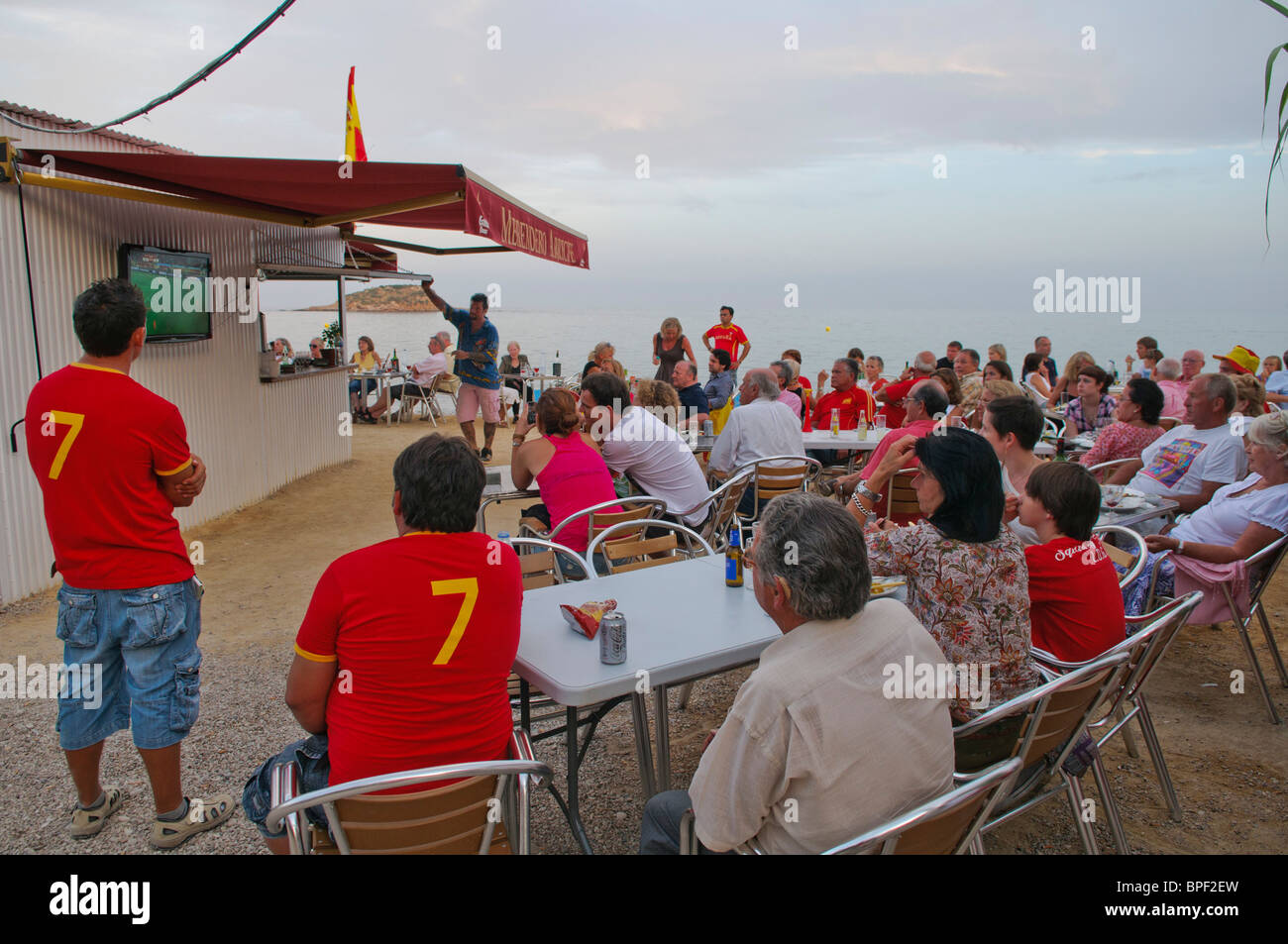 football fans watch the FIFA World Cup 2010 Final on large TV screens outside beach bar near Altea on the Costa Blanca, Spain Stock Photo