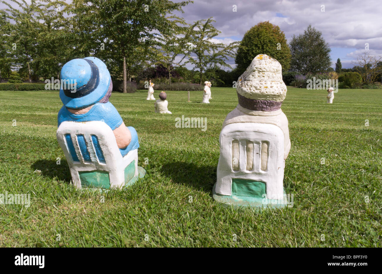 Garden ornaments - miniature cricket match with garden gnome type pottery figures watching players on lawn of Clow Beck House Stock Photo