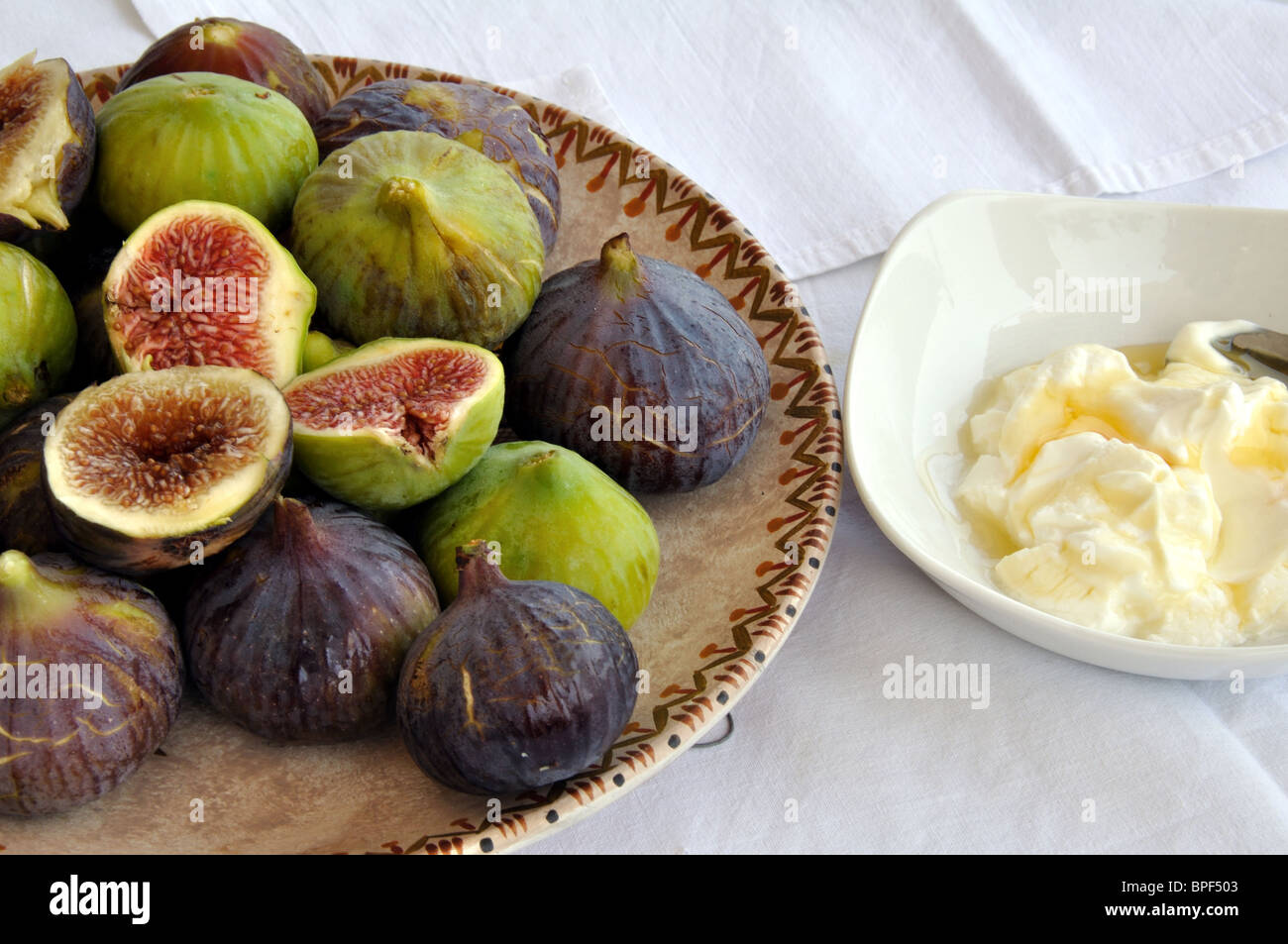Fresh figs on an old Greek plate, Greek yoghurt and honey Stock Photo