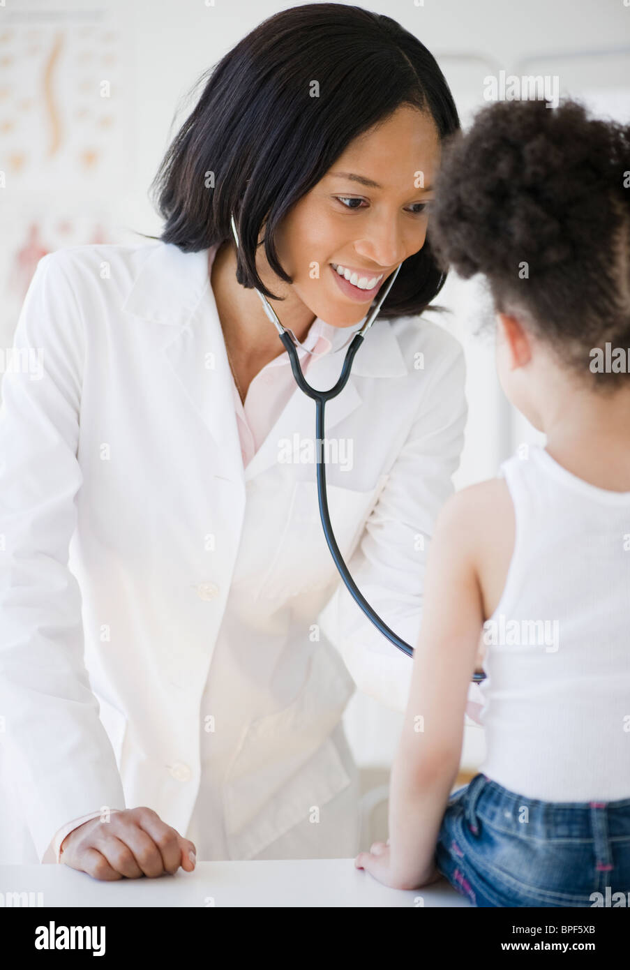 Pediatrician with stethoscope examining patient Stock Photo