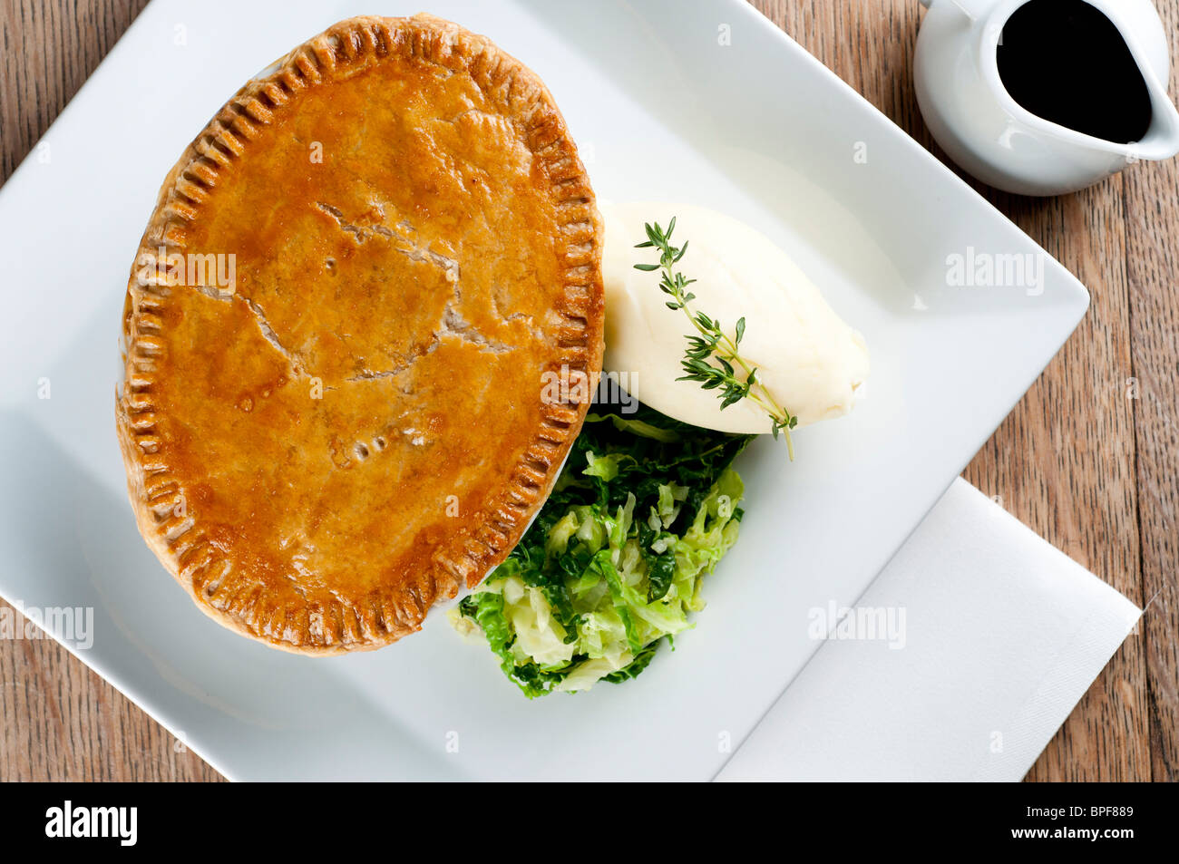 Traditional british pub food - big pie with mash and vegetables Stock Photo