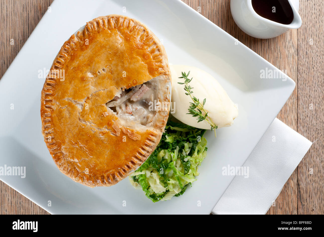 Traditional british pub food - big pie with mash and vegetables Stock Photo