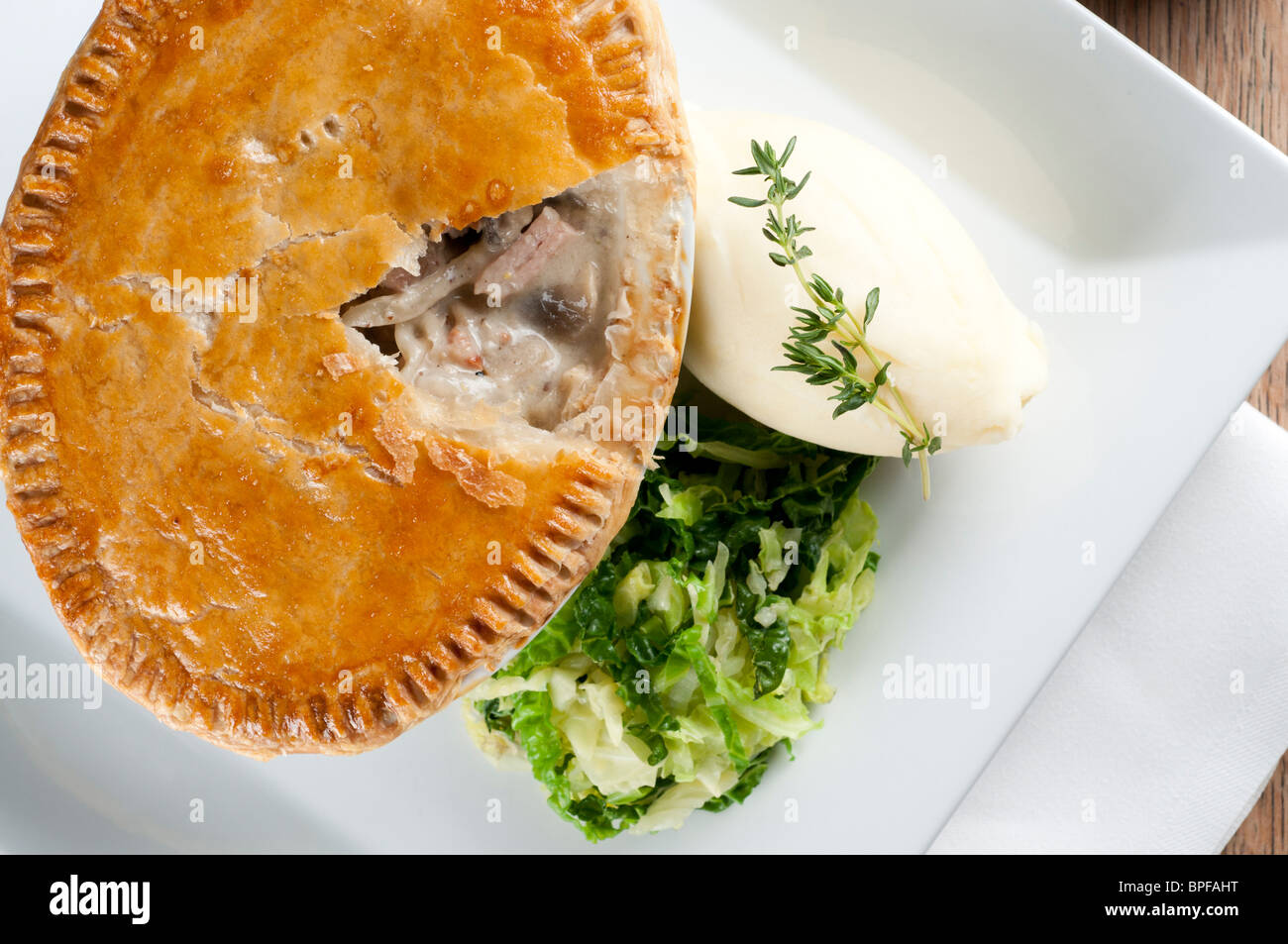 Traditional british pub food big pie with mash and vegetables Stock