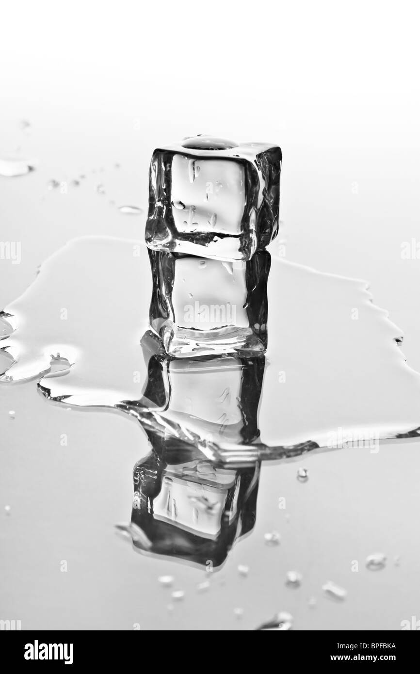 Melting ice cubes on a reflective tabletop Stock Photo - Alamy