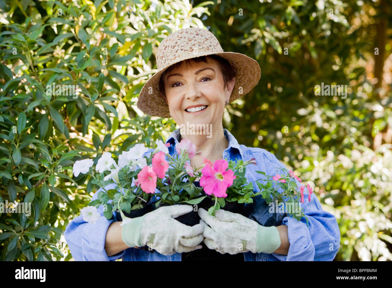 Hispanic woman in garden holding flowers Stock Photo - Alamy
