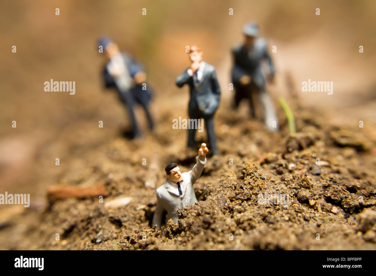 Business figurines placed outside in the dirt Stock Photo