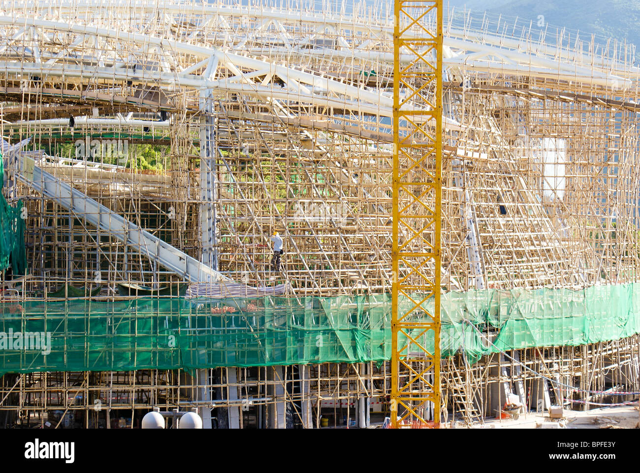 Large bamboo scaffold on a construction site in china. You can see the scale by comparing to the builder in the frame. Stock Photo