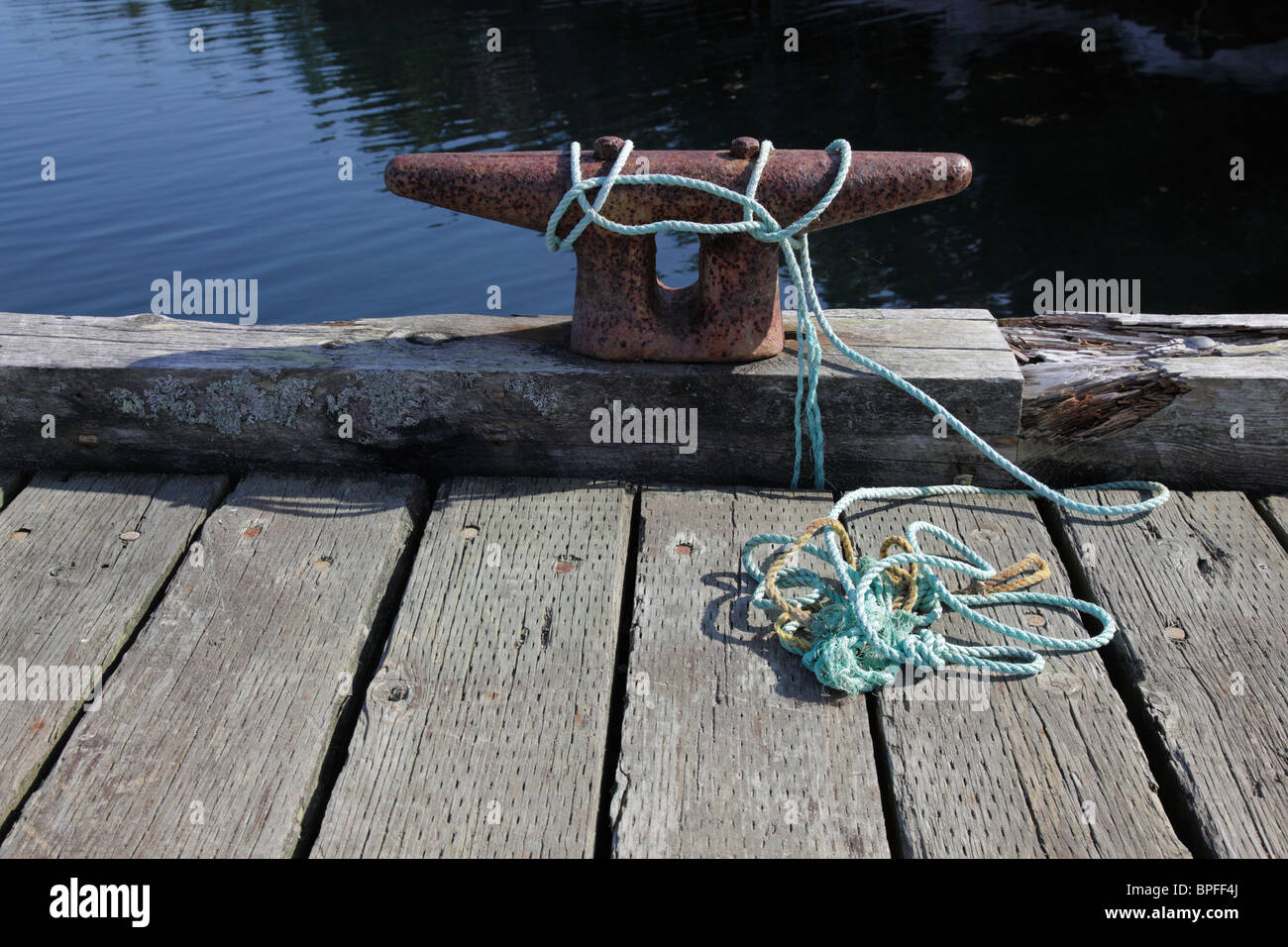 Mooring line with rope and nautical knots and cleat at dock in Peggys