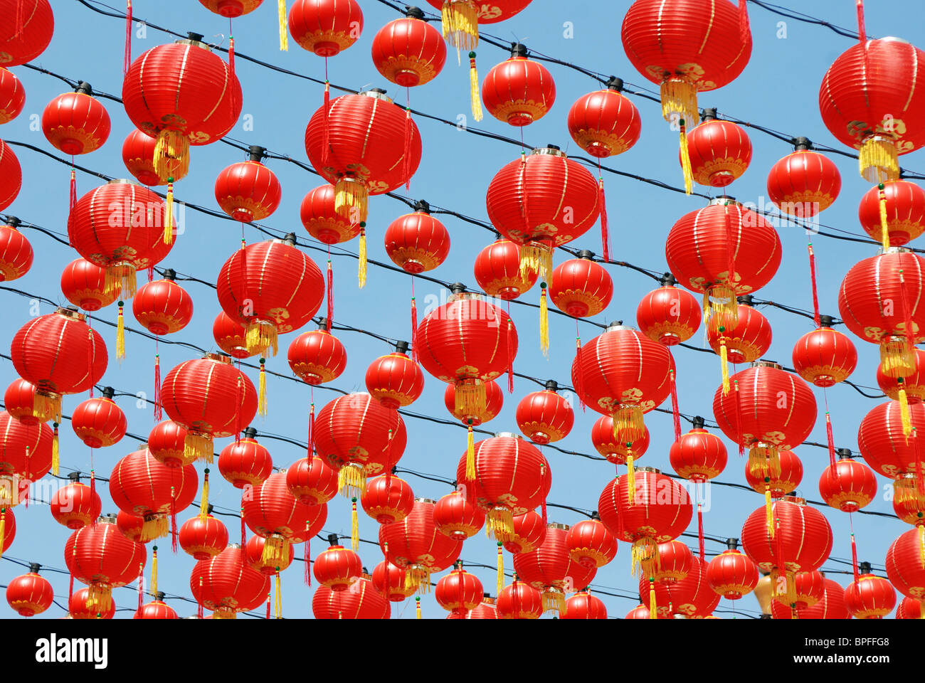 Many red Chinese lanterns hanging in rows above Stock Photo - Alamy