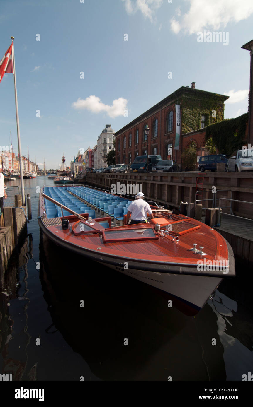 A canal cruise boat ready to take passengers on a tour in Nyhavn Harbour, Copenhagen, Denmark. Stock Photo