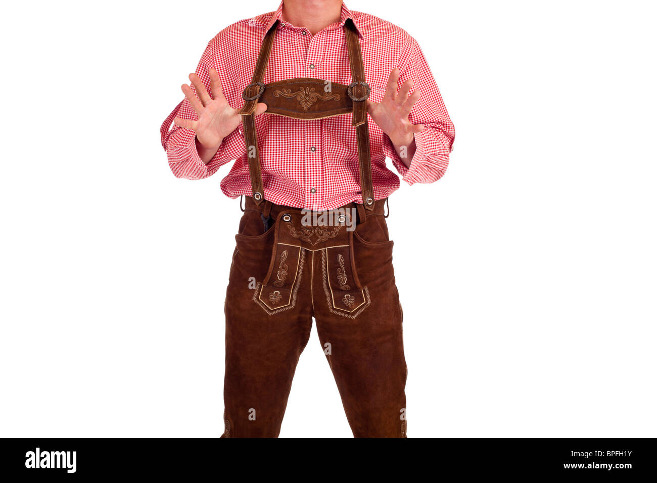 Bavarian man with oktoberfest leather trousers holds his suspenders. Isolated on white background. Stock Photo