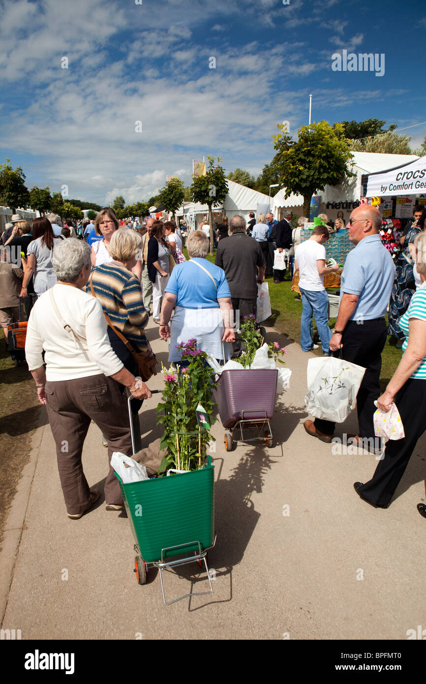 UK, England, Merseyside, Southport Flower Show, visitors carrying bought plants in wheeled shopping baskets Stock Photo