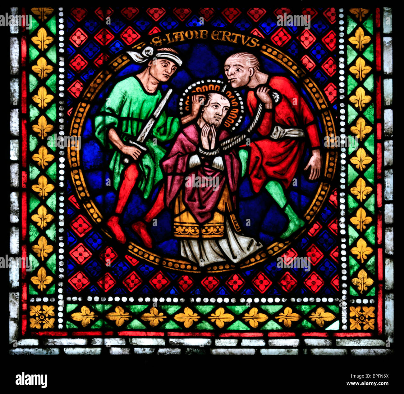 A medieval stained glass window depicting the Martyrdom of Saint Lambert, Freiburg Münster, Baden Wurtemburg, Germany Stock Photo