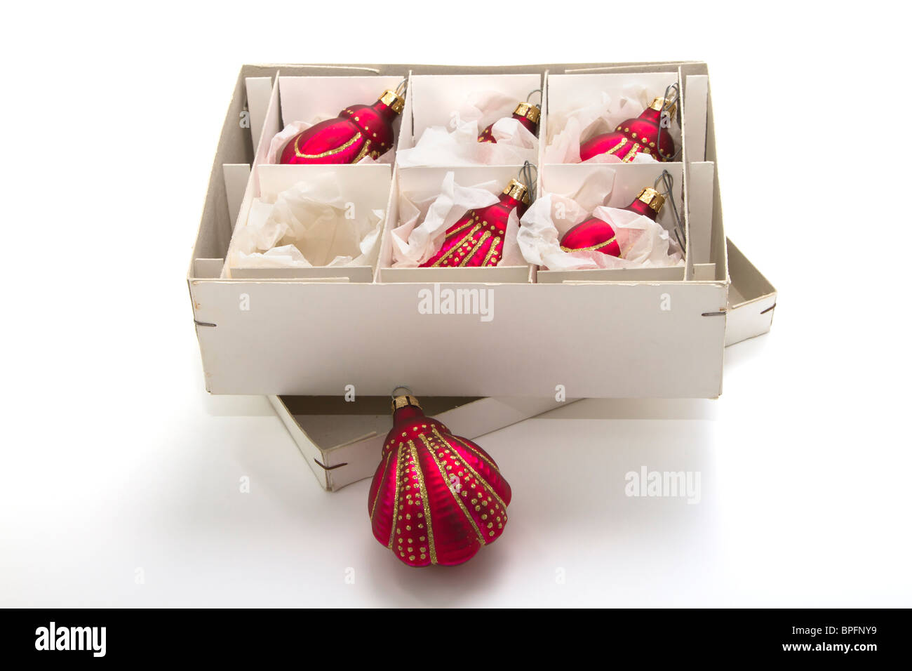 An open box of beautiful hand blown glass Christmas decorations on a white background Stock Photo