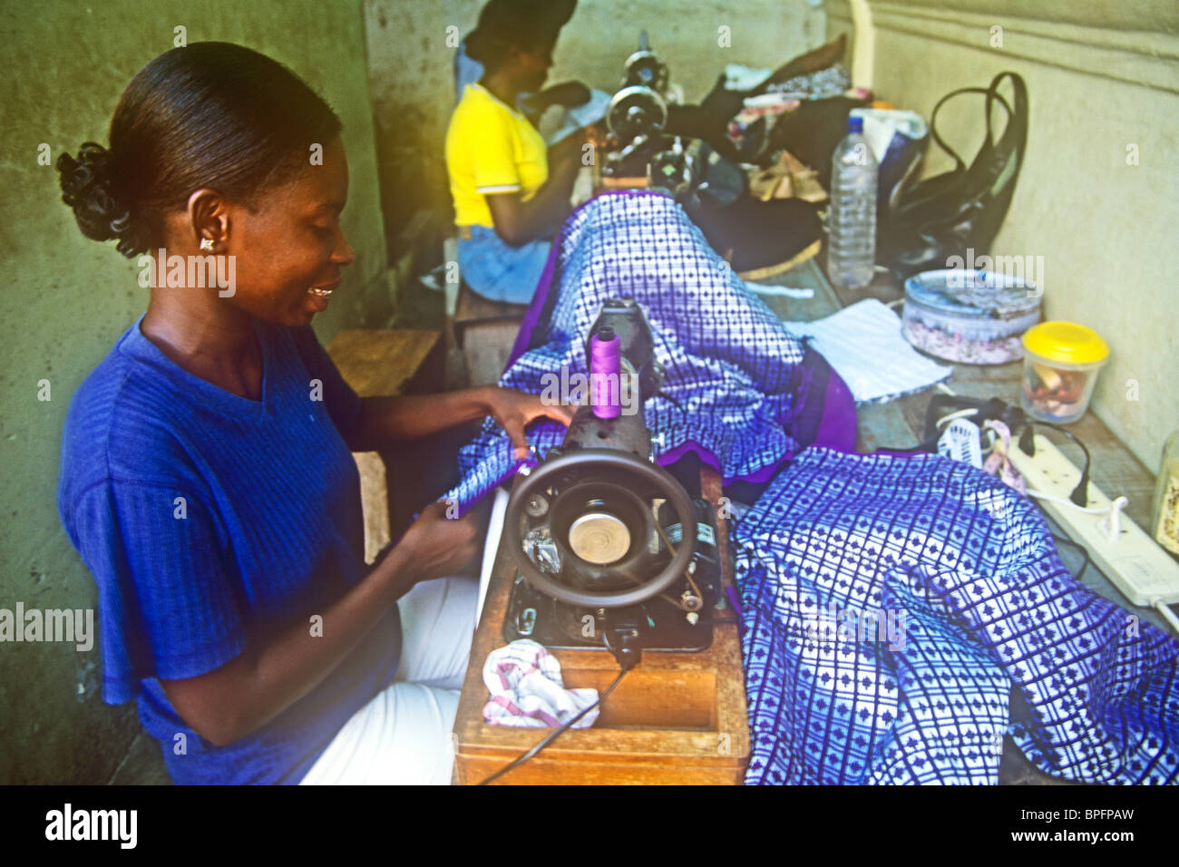 Women tailors using hand operated sewing machines in Accra Ghana Stock