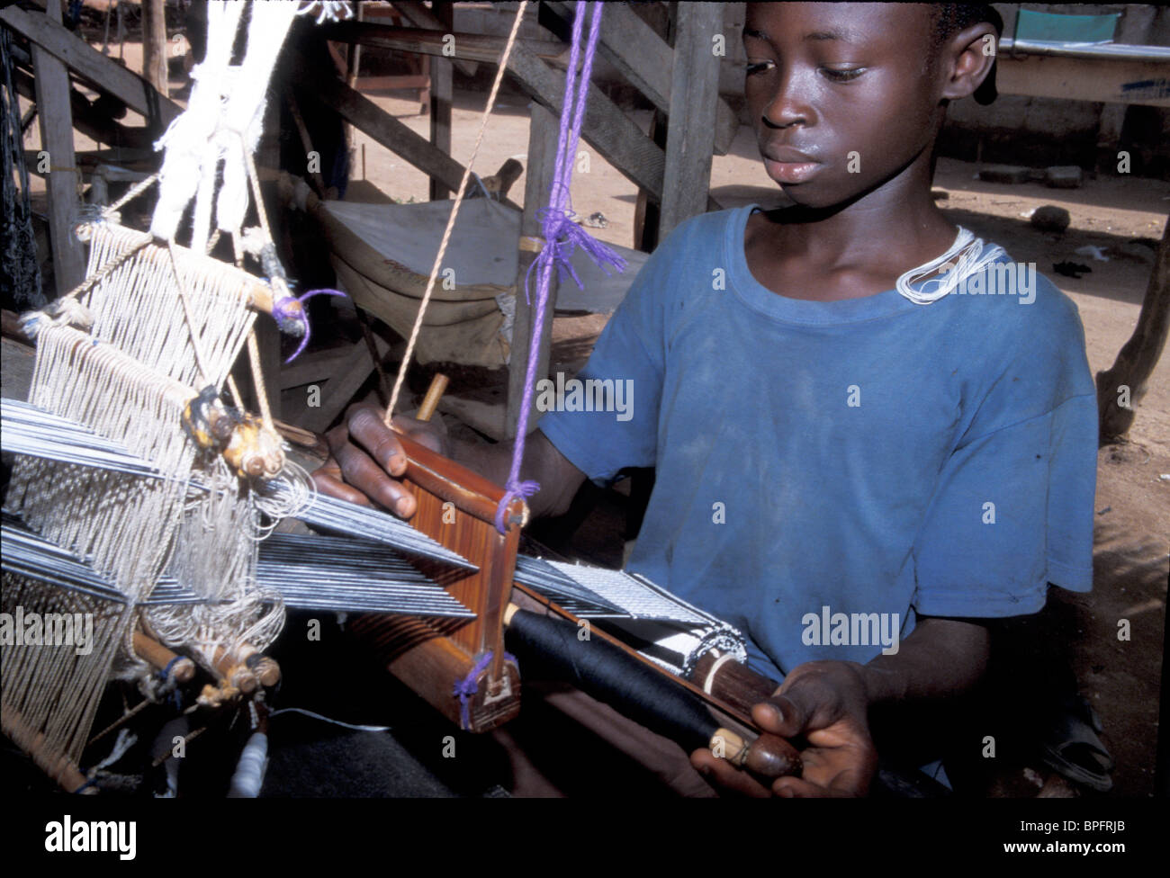 Ashanti boy weaving kente cloth in Bonwire, Ghana Stock Photo