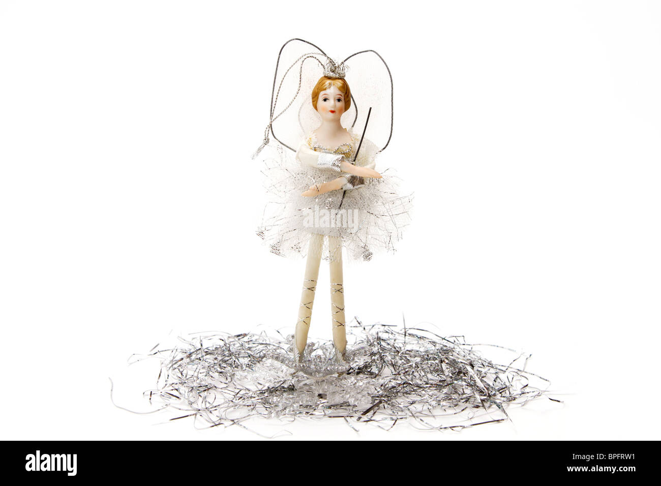 White and silver treetop fairy Christmas ornament standing on tinsel on a white background Stock Photo