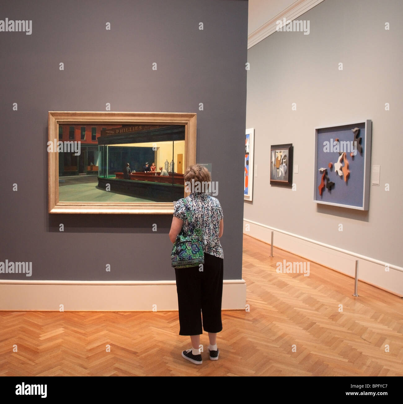 Woman studies 'Nighthawks' by Edward Hopper at the Art Institute in Chicago Stock Photo