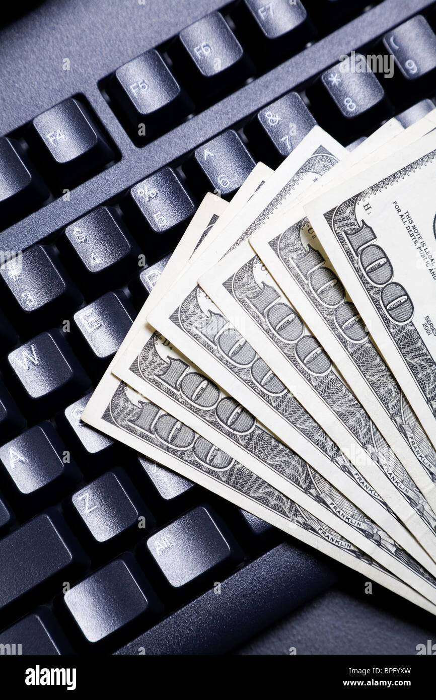 100 dollar bills fanned out on top of a computer keyboard Stock Photo