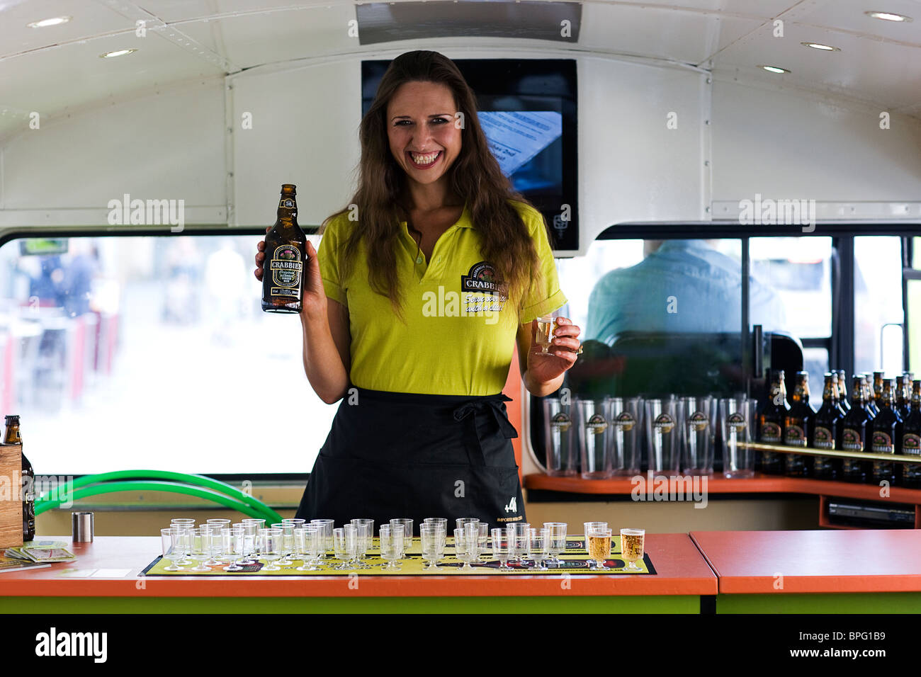 Pretty girl serving ginger beer on bus. Edinburgh. Stock Photo