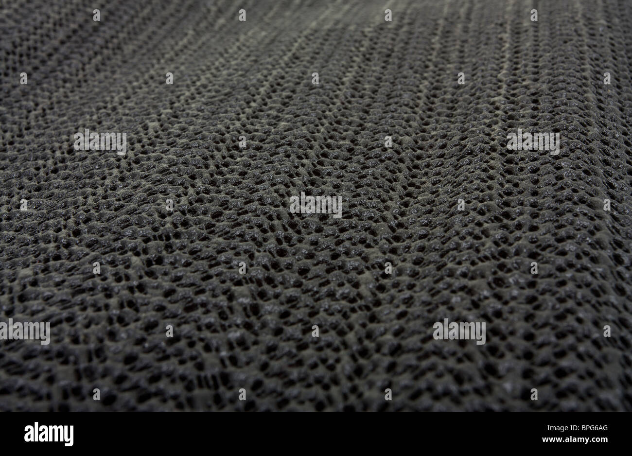 Black non slip Silicon or rubber mat background or texture with shallow focus and diminishing perspective. Stock Photo