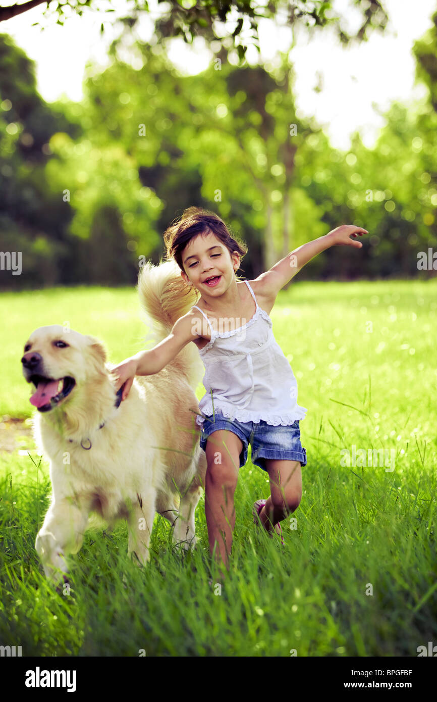 Young girl with golden retriever running outdoors Stock Photo - Alamy