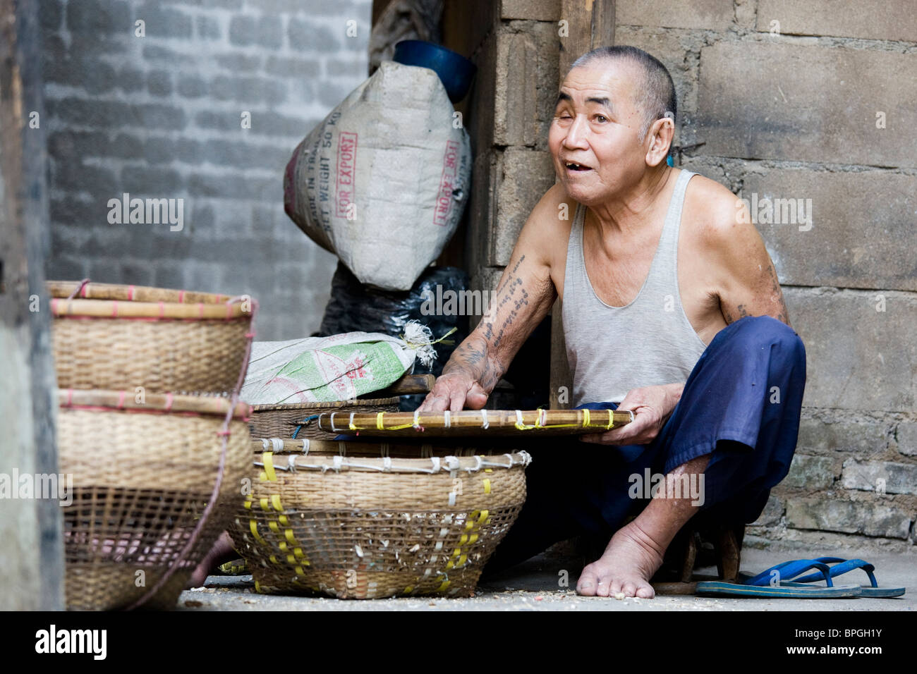 An old Asian man processing rice Stock Photo - Alamy