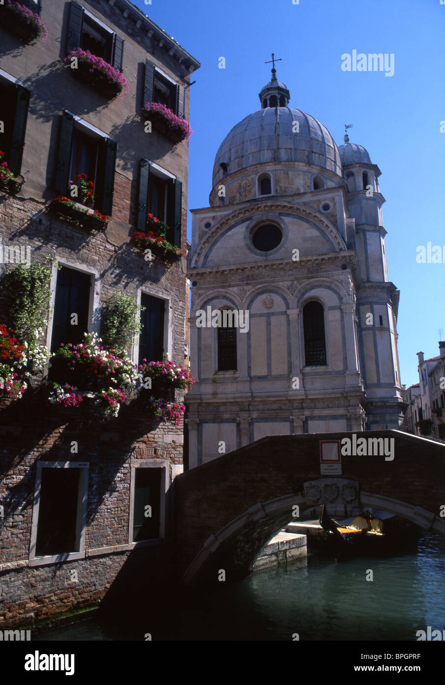 Church of Santa Maria dei Miracoli, flower-decked palazzo, bridge and canal (Rio dei Miracoli) Venice Veneto Italy Stock Photo