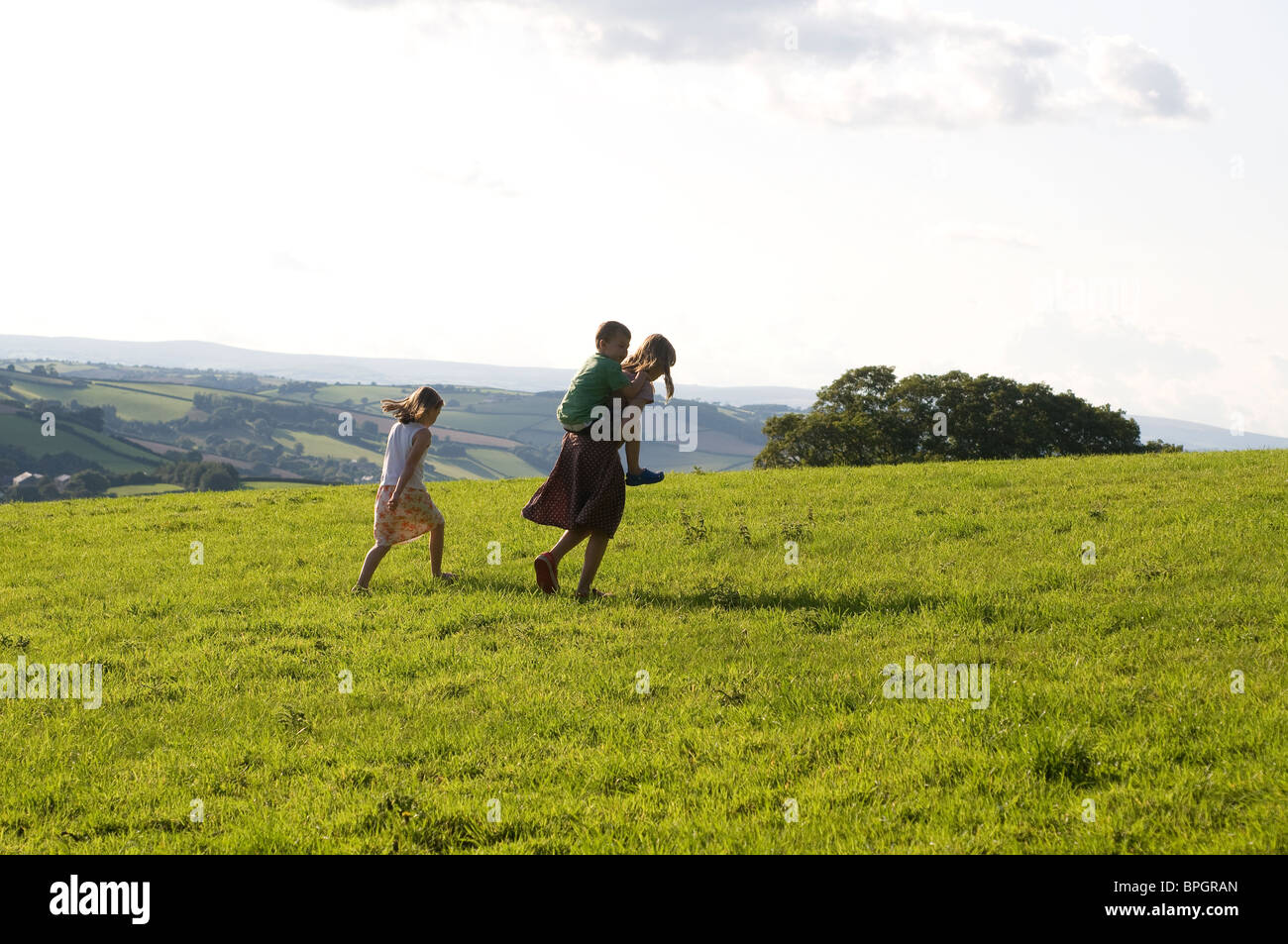He ain't heavy he's my brother,Brother and sisters in fields over Dittisham,Devon end of the day,Adventure,fun,holidays, Stock Photo