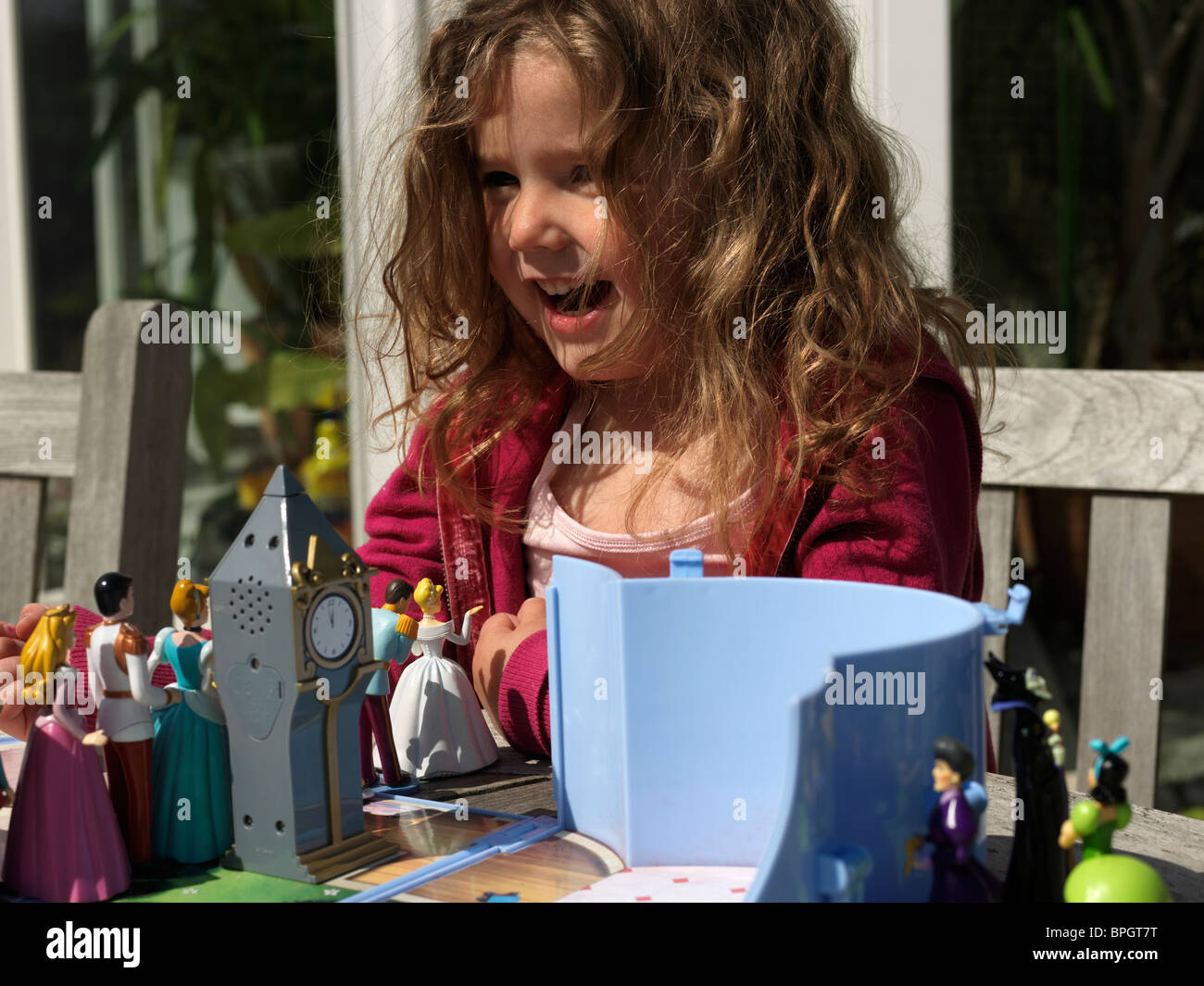 Young Girl Playing With Princess Dolls In The Garden England Stock Photo