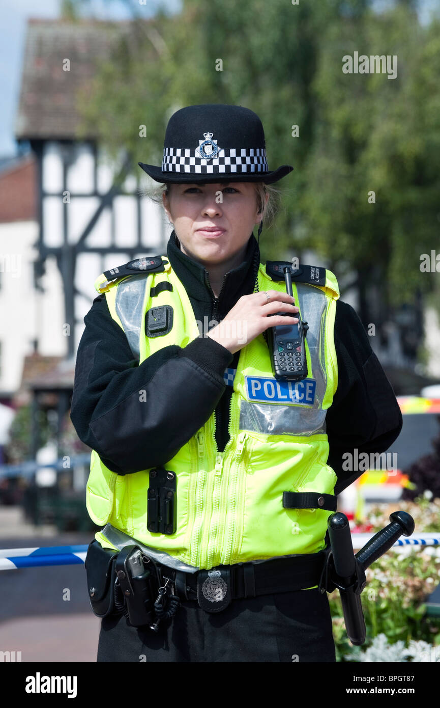 Front view of WPC woman police officer guarding a crime scene in Hereford City centre, UK. Police line do not cross. Old House. Stock Photo