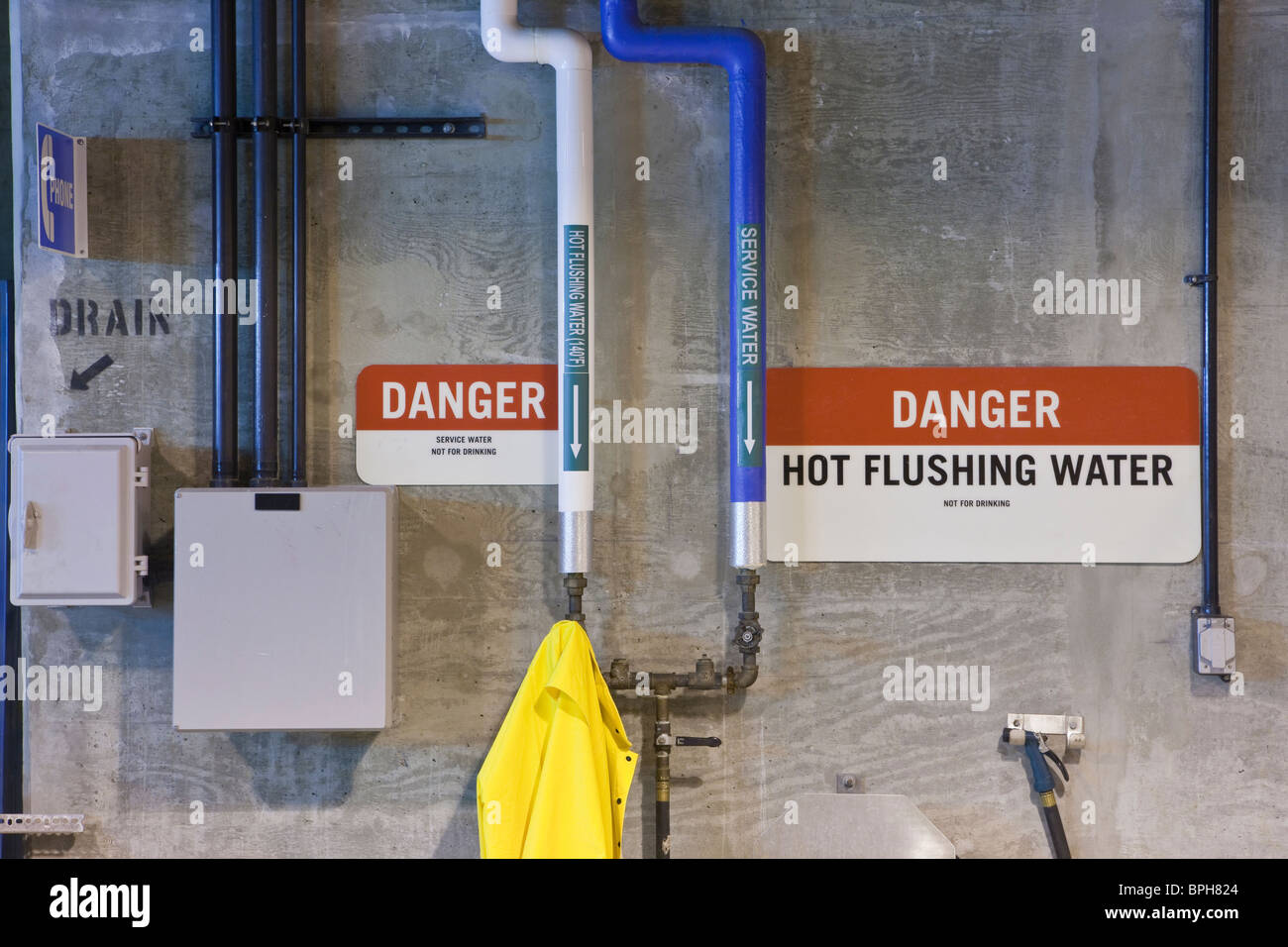 Hot flushing water pipes with warning sign in a sewage treatment plant, Massachusetts, USA Stock Photo